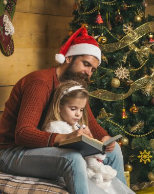 Noel mutlu çocuk ve baba kitap okumak.