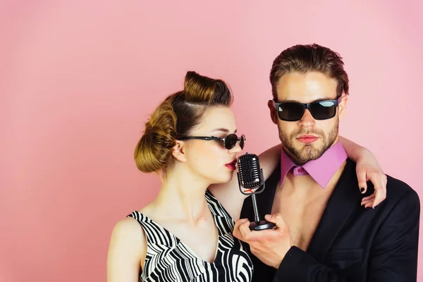 Couple in love in glasses sing in microphone. — Stock Photo, Image