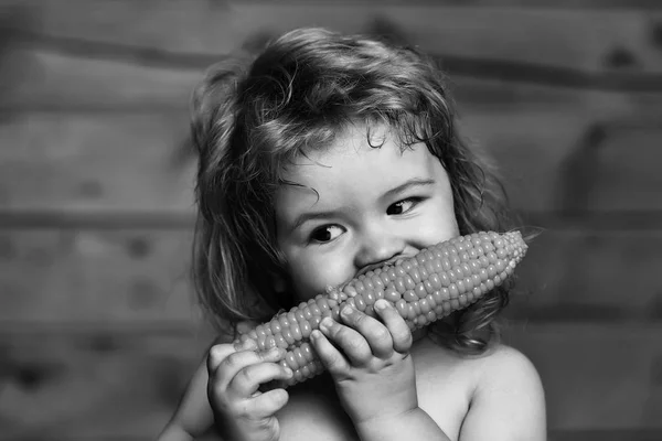 Legrační malý chlapec dítě jíst žlutá kukuřice — Stock fotografie