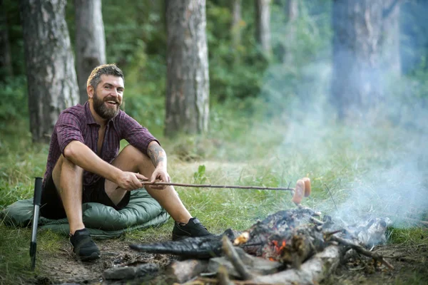 Хипстер с бородой счастливая улыбка и жареные сосиски — стоковое фото