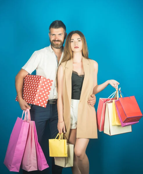 Couple in love hold shopping bag near blue wall.