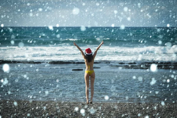 Жінка в капелюсі Санта Клауса, що піднімається руками на блакитне небо — стокове фото