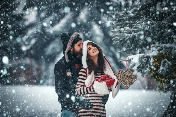 Pár v lásce s červeným kloboukem santa claus v zimě. — Stock fotografie