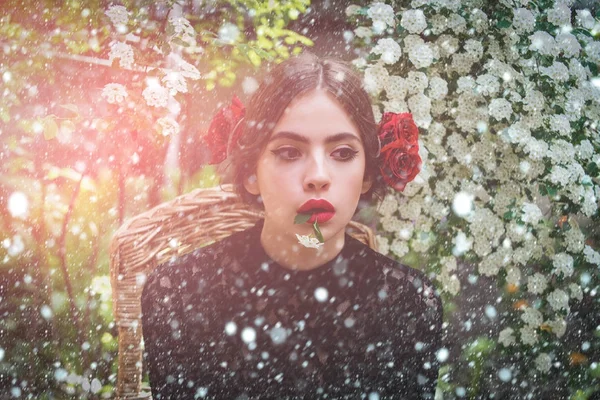 Schattig meisje met witte bloem in mond op doordachte gezicht — Stockfoto