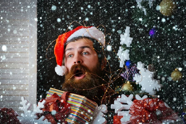 Homem de natal com barba no rosto surpreso com caixa de presente — Fotografia de Stock