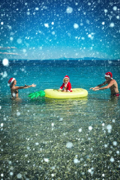 Christmas happy family on pineapple mattress in water. — Stock Photo, Image