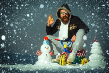 Mutlu adam gri gökyüzü üzerinde üç tekerlekli bisiklet sürme