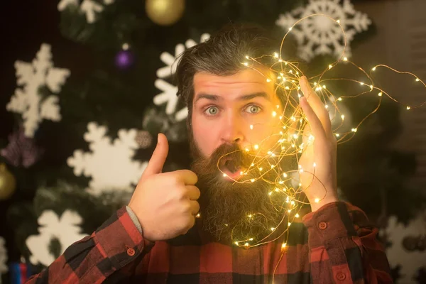 Weihnachtsmann mit Bart im überraschten Gesicht und Girlanden. — Stockfoto