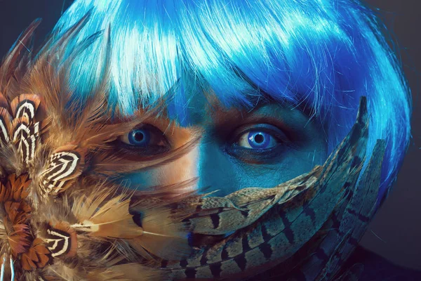 Człowiek w niebieskim wig behing piór — Zdjęcie stockowe