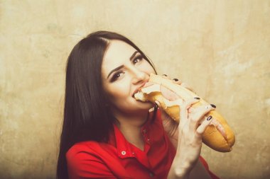 seksi güzel esmer gülümseyen kadın koca sandviç ya da hamburger yiyor