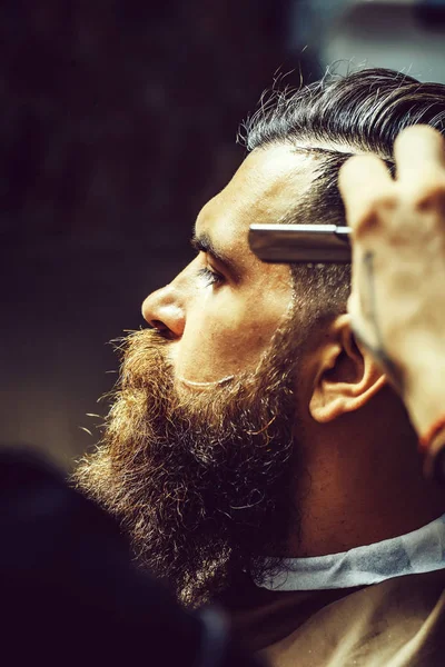 Vousatý muž s dlouhým vousem se vlasy holení s holicí strojek — Stock fotografie