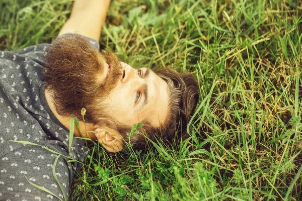 Бородатый человек лежит на зеленой траве — стоковое фото