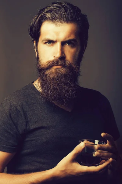 Бородатий чоловік з келихом бренді або віскі — стокове фото