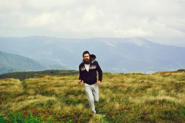 El hombre corre en la cima de la montaña — Foto de Stock