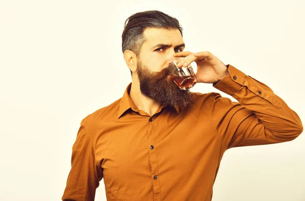 Hipster poważne Brodaty mężczyzna z whisky szkła w shirt pomarańczowy — Zdjęcie stockowe