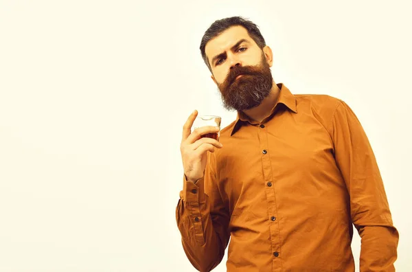 Серйозна бородата людина хіпстер з віскі склянкою в помаранчевій сорочці — стокове фото