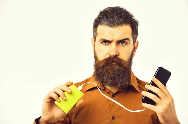 Ciddi sakallı adam hipster güç banka ile cep telefonu şarj — Stok fotoğraf