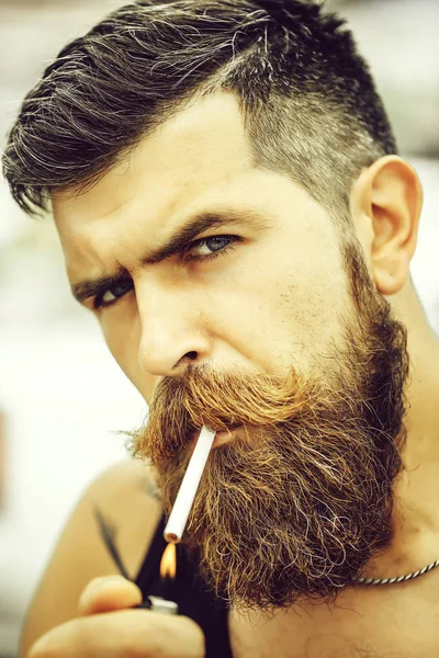 Homme barbu froncé fumant la cigarette — Photo