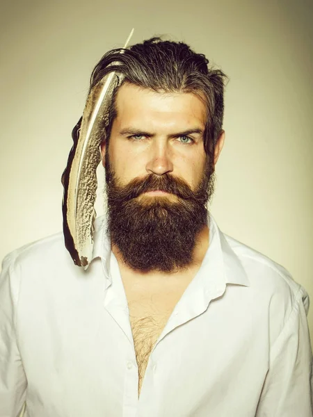 Brodaty mężczyzna z piór w włosy — Zdjęcie stockowe