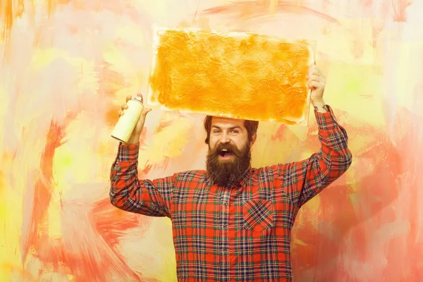 happy bearded man holding orange oil paint texture on canvas