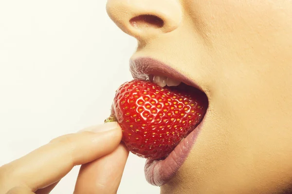 Labios femeninos comiendo fresa roja — Foto de Stock