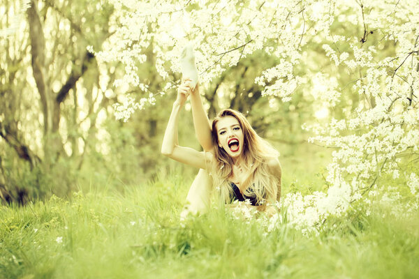 Beautiful happy young woman enjoying beauty in a flowering spring garden