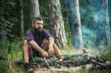 Hipster uzun yürüyüşe çıkan kimse kızartma sosis Stick yanan orman