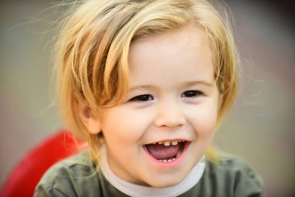 Menino com cabelo loiro sorriso no rosto bonito ao ar livre — Fotografia de Stock