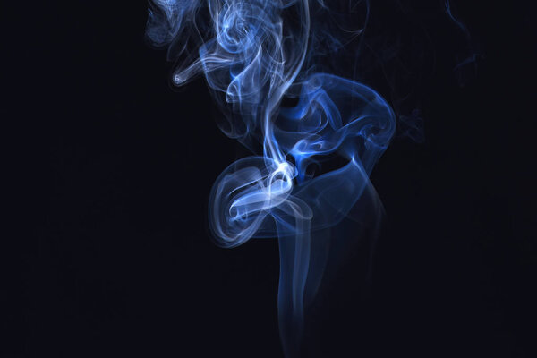 Blue ink in freeze motion, powder splatted explosion. Smoking cloud backdrop. Abstract background with smoke. Blue smoke on black background. Spirit and ghost, miracle.