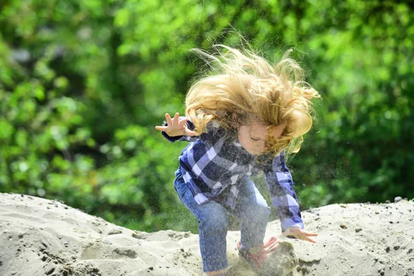 Garçon sauter sur pile de sable le jour idyllique — Photo