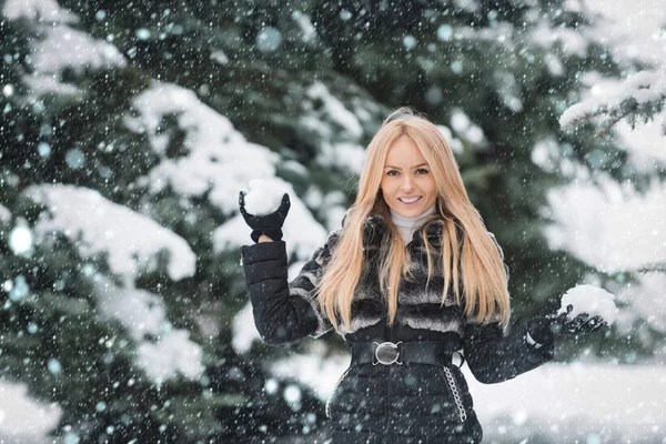 Kobieta z długimi blond włosami, uśmiechając się w drewno śnieg — Zdjęcie stockowe