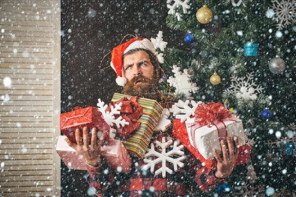 Weihnachtsmann mit Geschenkschachtel am Weihnachtsbaum. — Stockfoto