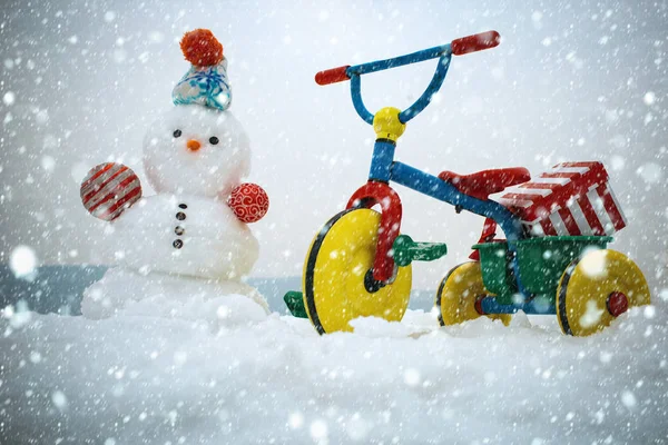 Kardan adam ve karlı zemin üzerine üç tekerlekli bisiklet — Stok fotoğraf