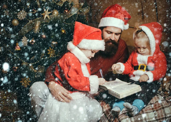 Weihnachtsfamilie mit bärtigem Vater und Kindern im Weihnachtsmann-Hut — Stockfoto