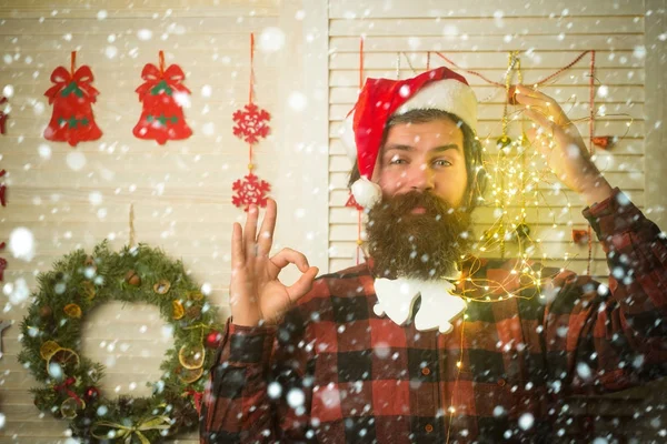 Christmas man with beard on happy face and garland.