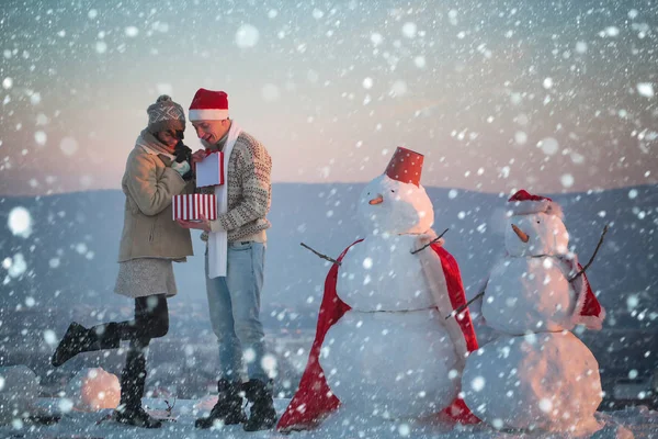 Babbo Natale muscoloso uomo e ragazza con pupazzo di neve . — Foto Stock