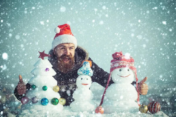 Santa man die lacht met besneeuwde sculpturen — Stockfoto