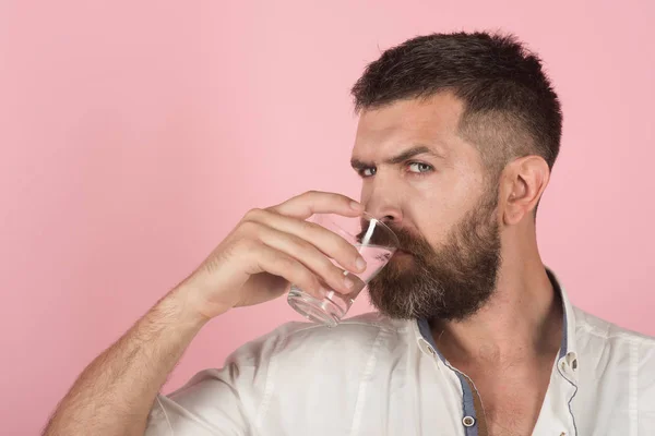 Mannen med skägg på ansikte dricka vatten från glas — Stockfoto