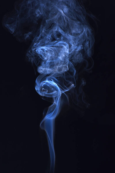 Abstract background with smoke. Spirit and ghost, miracle. Blue ink in freeze motion, powder splatted explosion. Smoking cloud backdrop. Blue smoke on black background.