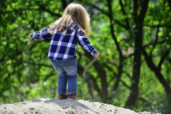 Niño con pelo largo y rubio en camisa, jeans al aire libre — Foto de Stock