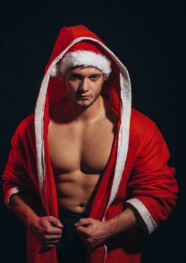 Yeni yıl şerit ve yetişkin için bir hediye. Noel Baba kırmızı paltolu kas vücut ile. Yılbaşı partisi ve seks oyunları. Genç adam Noel Baba kostüm, kızlar için mevcut. Erkek ya da seksi sporcu adam xmas ara.
