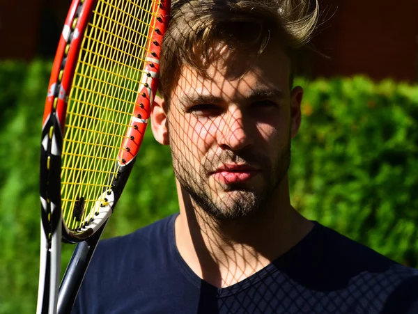 Man sportsman with net shadow on bearded face on court