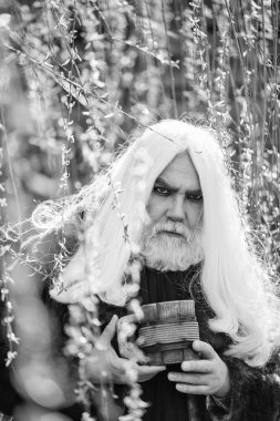 Kupa çiçek ile sakallı adam