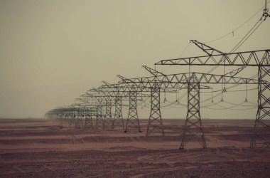 Çöl gri gökyüzü arka plan üzerinde güç hattı kuleleri