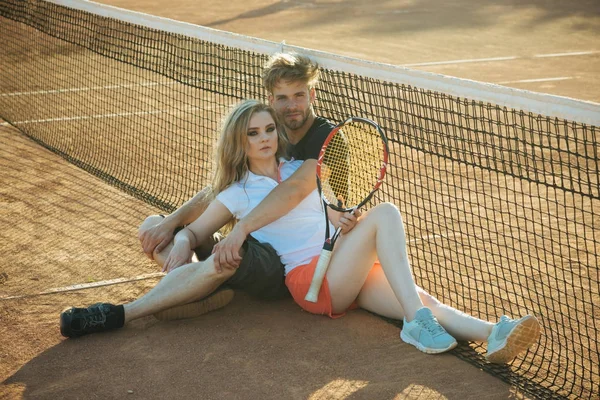 Para zakochanych siedzieć na kort tenis net — Zdjęcie stockowe