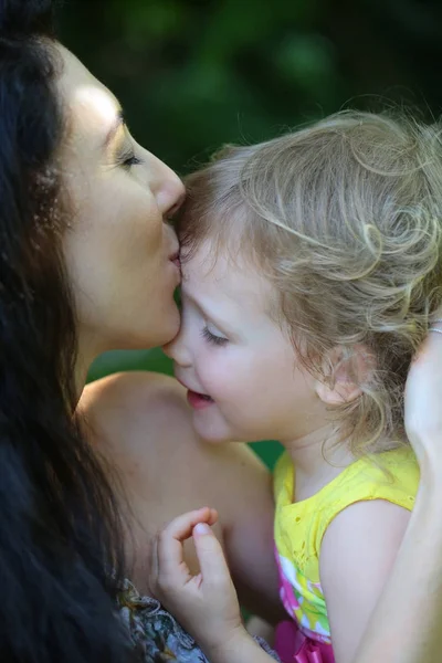 Mãe beijo bebê menina ao ar livre — Fotografia de Stock
