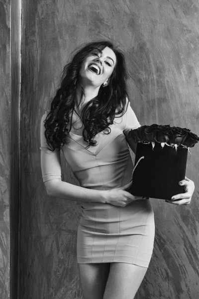 Ganska glad tjej skrattar med röda rosor i låda — Stockfoto
