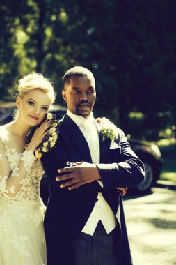 Güzel kız veya sevimli gelin yakışıklı Afro-Amerikan groo sarılma