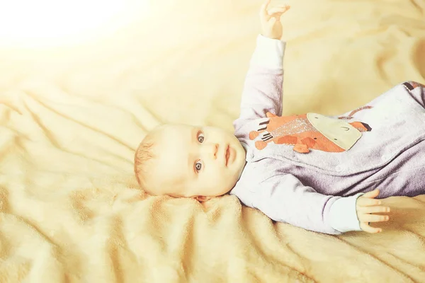 Kleines süßes fröhliches Baby auf dem Bett — Stockfoto