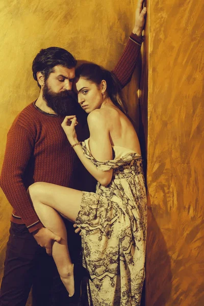 Серьезный бородатый мужчина с сексуально поднятой ногой красивой девушки — стоковое фото